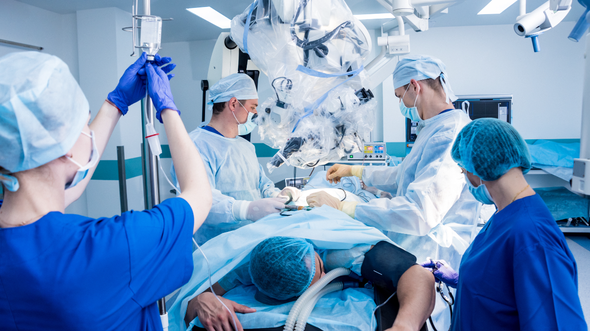 Orthopedic surgical team operating under a microscope in the operating room