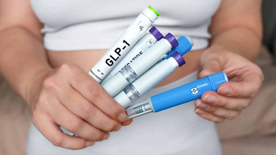 Person holding several GLP-1 weight-loss injection pens